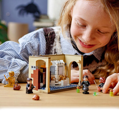 Child playing with LEGO Harry Potter Potion Mistake Set, featuring characters and Hogwarts bathroom scene.