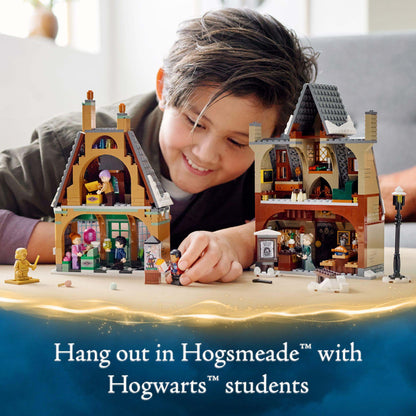 Child playing with LEGO® Harry Potter Hogsmeade Village set, featuring Hogwarts™ students and village shops.