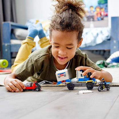 Child playing with LEGO® City Police Prisoner Transport Truck 60276, enjoying imaginative building fun.