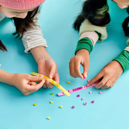Kids creating colorful LEGO® DOTS Ice Cream Besties Bracelets with vibrant tiles on a blue background.