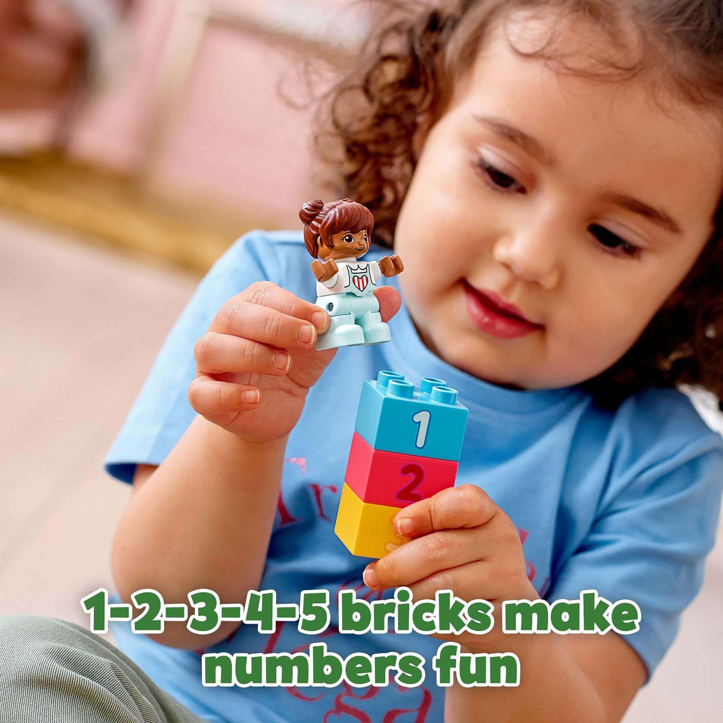 Child playing with LEGO® DUPLO bricks, showcasing number learning with colorful blocks and a cheerful expression.