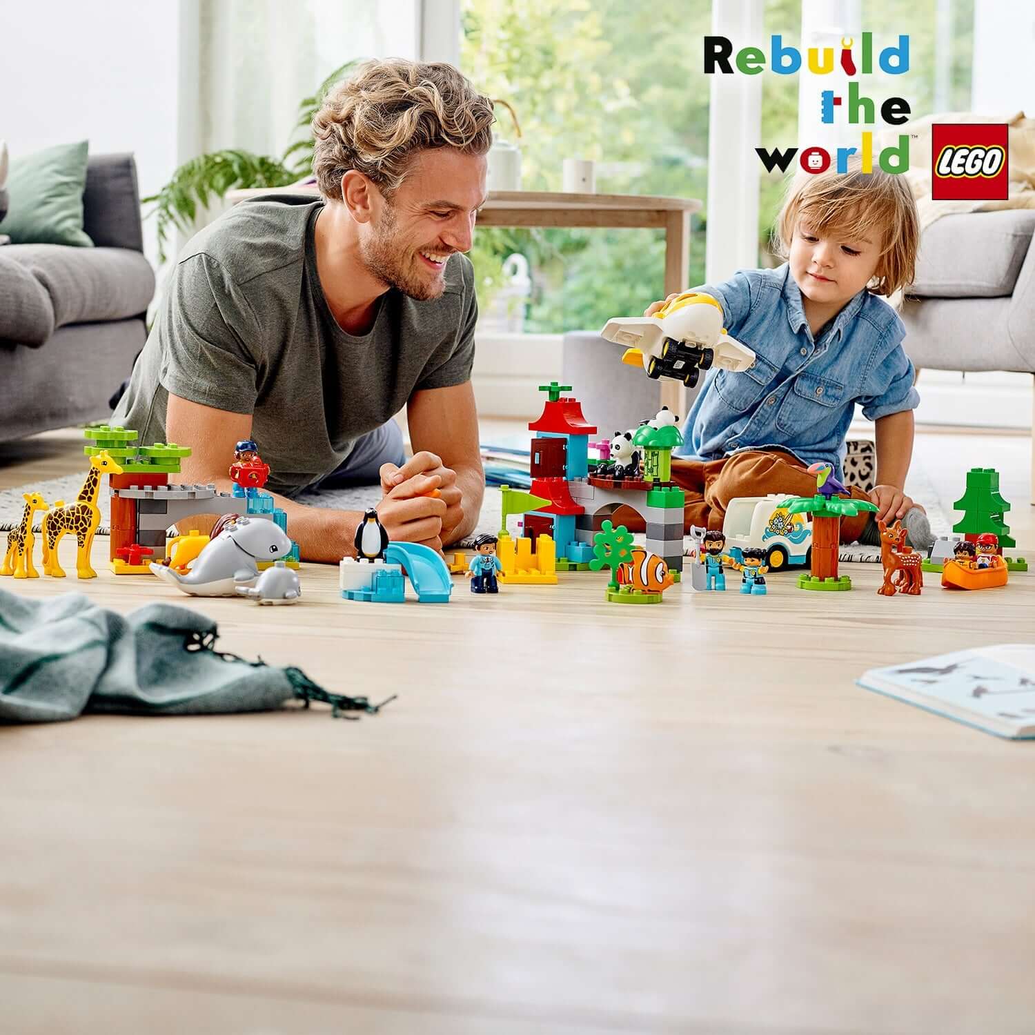 Dad and child playing with LEGO® DUPLO Town World Animals set, enjoying imaginative buildable environments with animals.