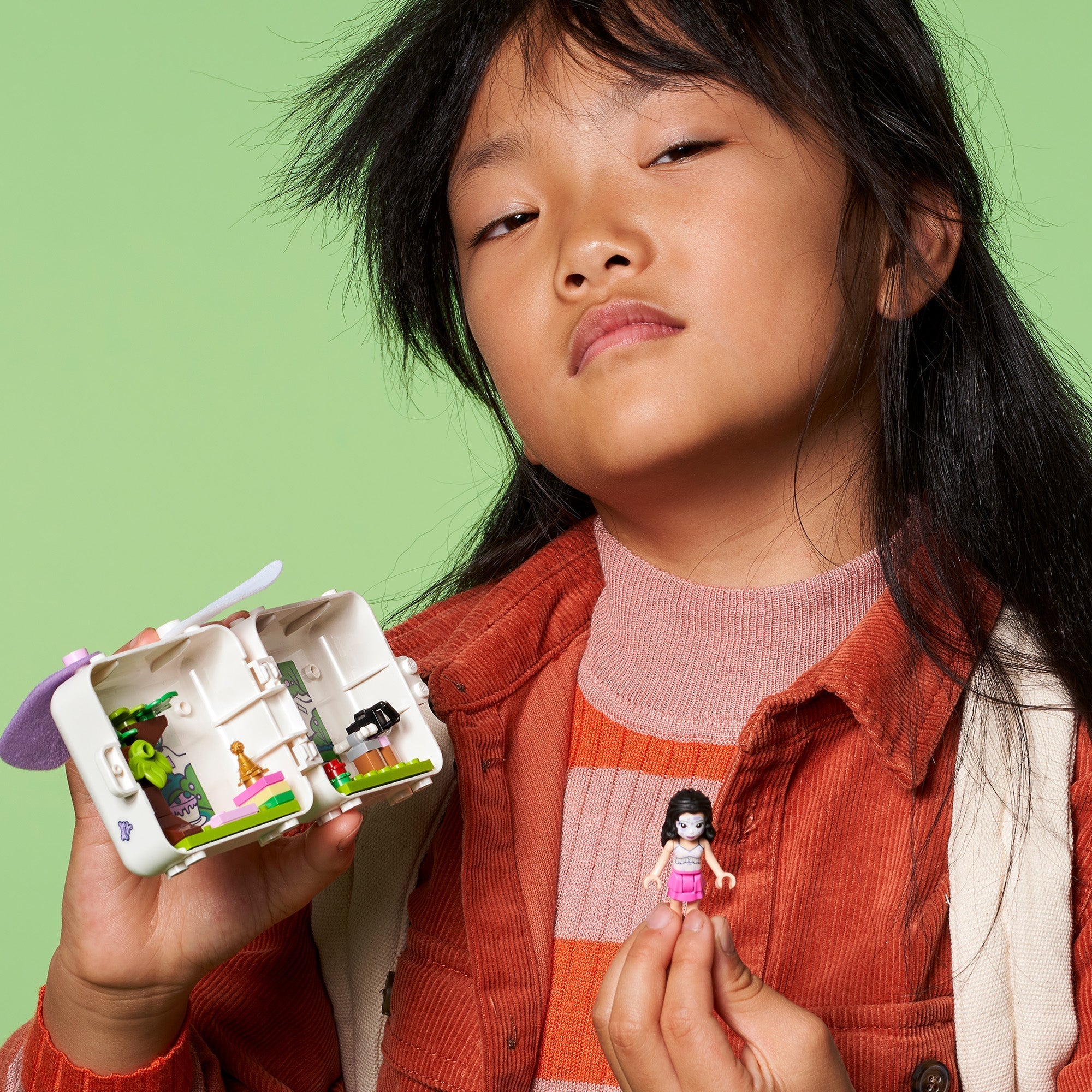 Child holding LEGO Friends Emma’s Dalmatian Cube Playset with adorable puppy and accessories.