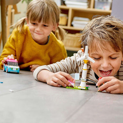 Kids playing with LEGO® Friends Olivia's Electric Car and charging station set, enjoying imaginative road trip adventures.