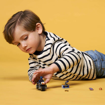 Child playing with LEGO® Marvel Captain America set, focusing on the motorcycle and accessories on a yellow background.