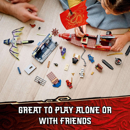 Children building and playing with the LEGO® NINJAGO Destiny's Bounty set with vibrant pieces on a wooden floor.