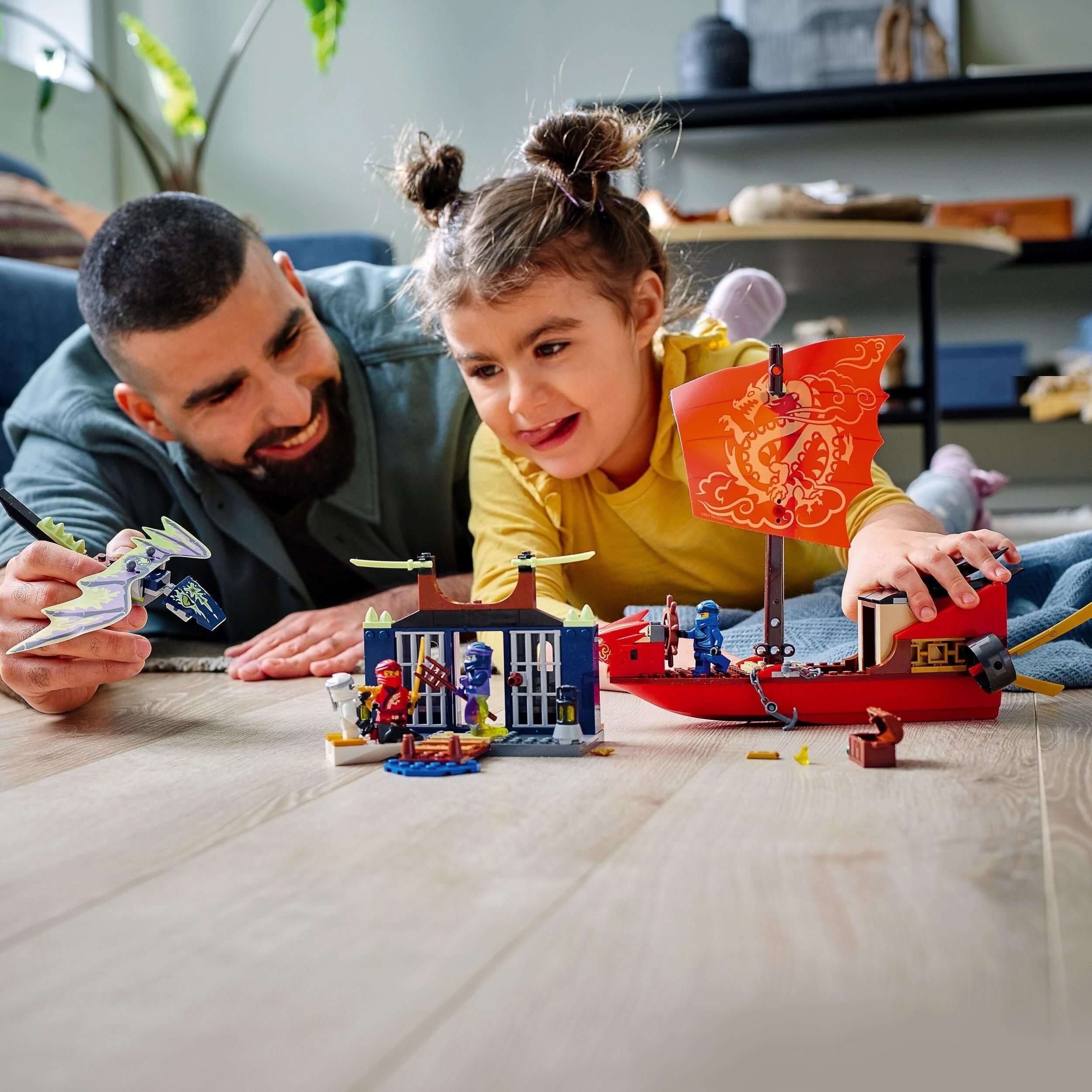 Father and daughter enjoy building the LEGO® NINJAGO Destiny’s Bounty ship set 71749 with minifigures and accessories.