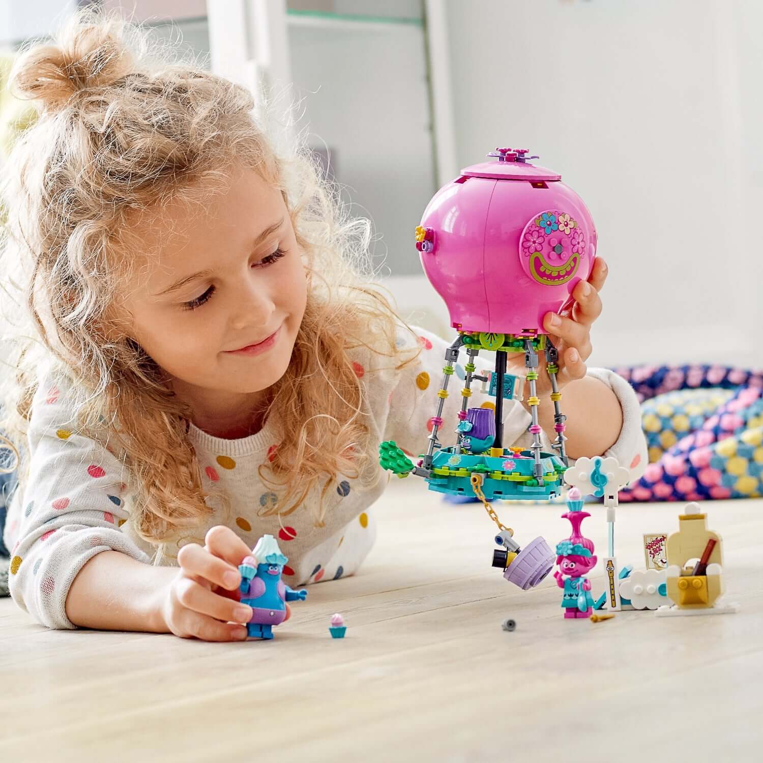 Child playing with LEGO Trolls Poppy's Hot Air Balloon Playset 41252, recreating scenes from the movie.