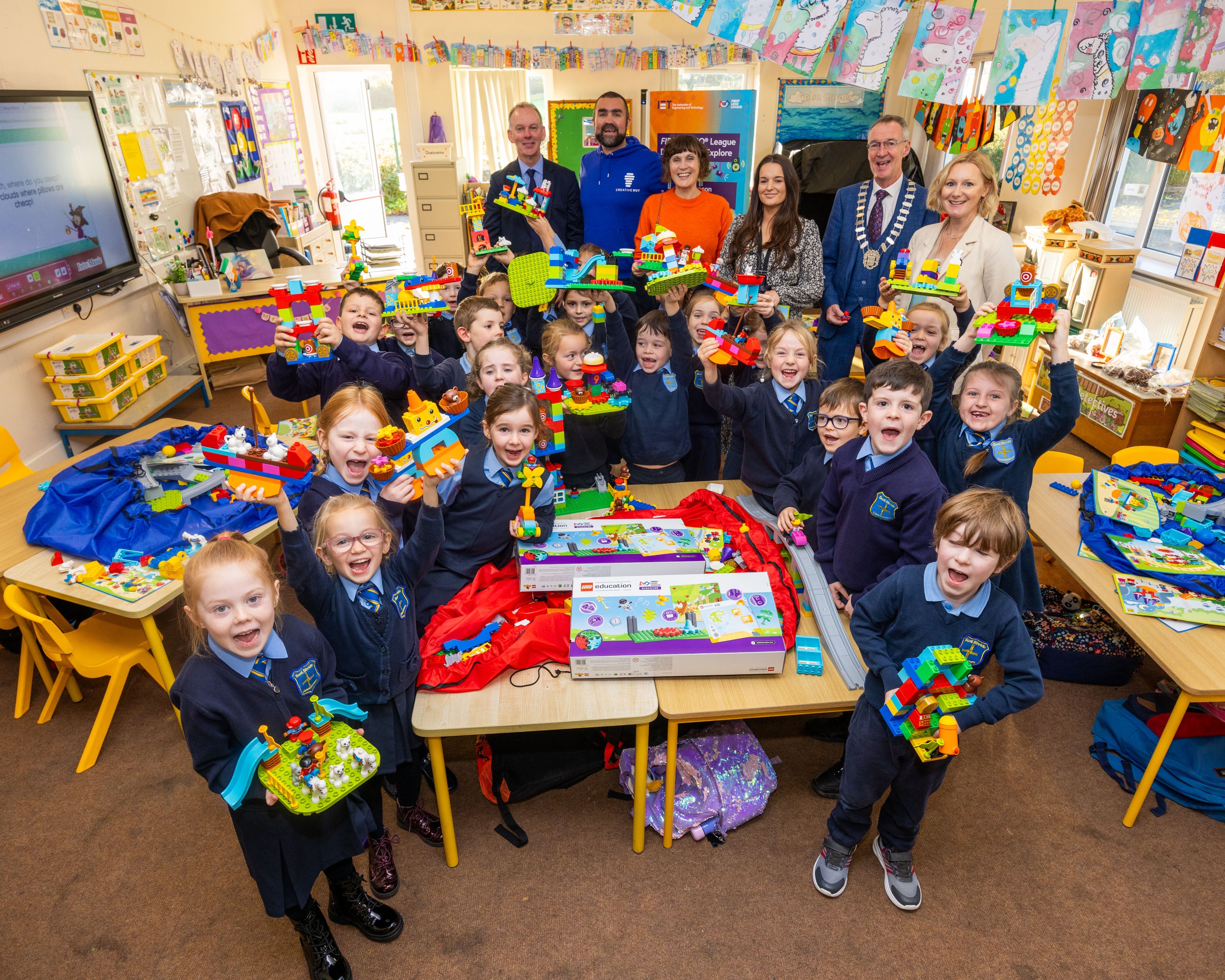 Group of happy children in classroom, showcasing colorful building blocks and engaging in creative play.