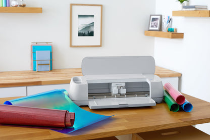 Cricut Maker 3 on a table with colorful materials, showcasing its cutting capabilities and creative potential.