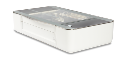 Glowforge Plus laser cutter machine with a sleek white design and transparent top for engraving and cutting.