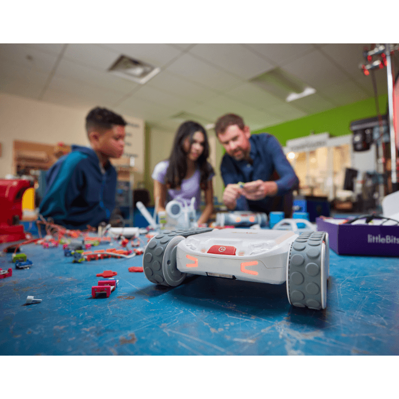 Students and instructor engaging with Sphero RVR+ robot in a creative learning environment with robotics components.