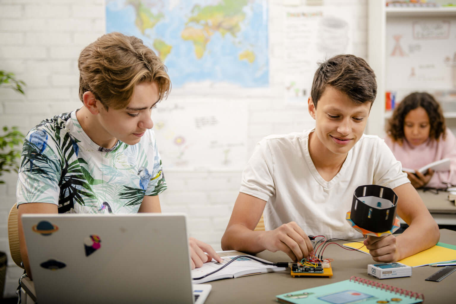 Students engaged in hands-on electronics projects with an Arduino education starter kit in a classroom.