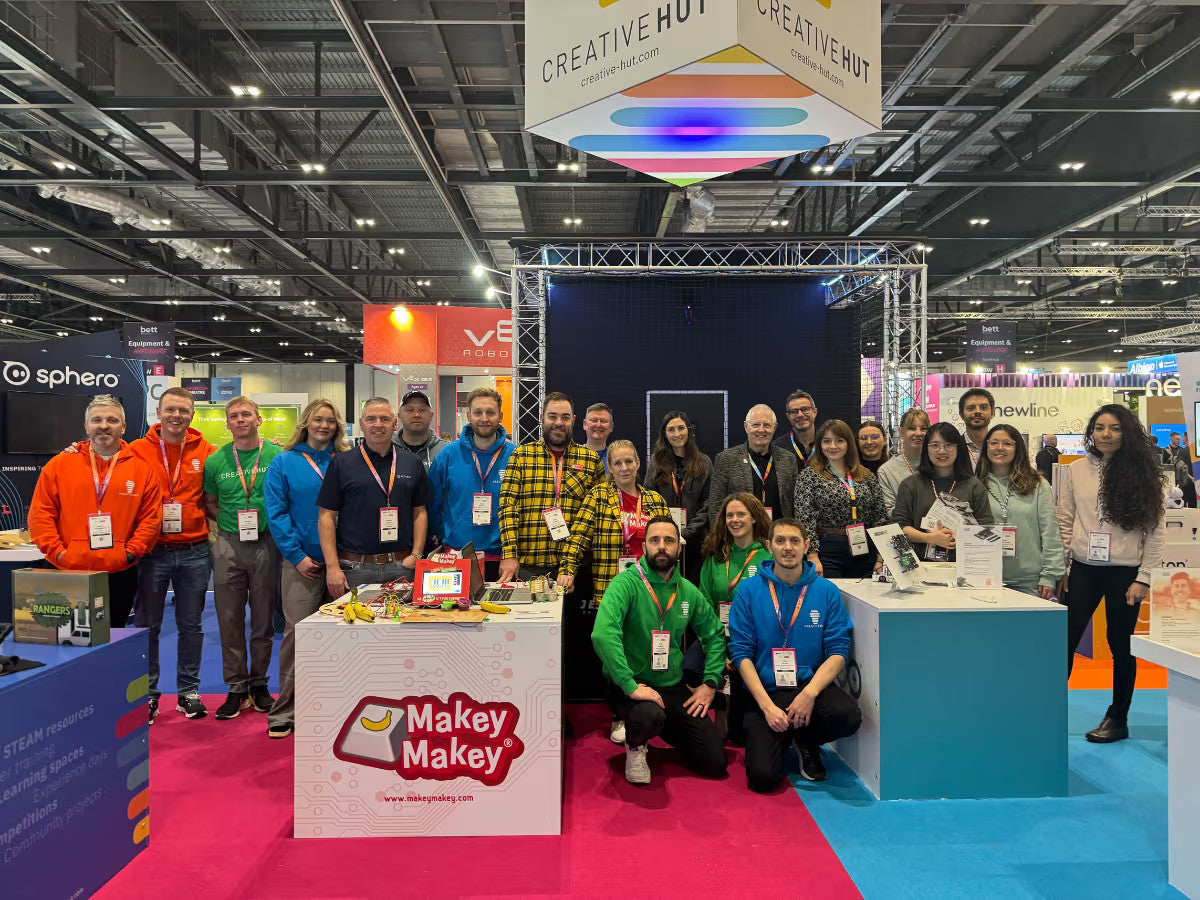 Group photo at Creative Hut booth showcasing Makey Makey products at a recent event, with attendees in colorful attire.