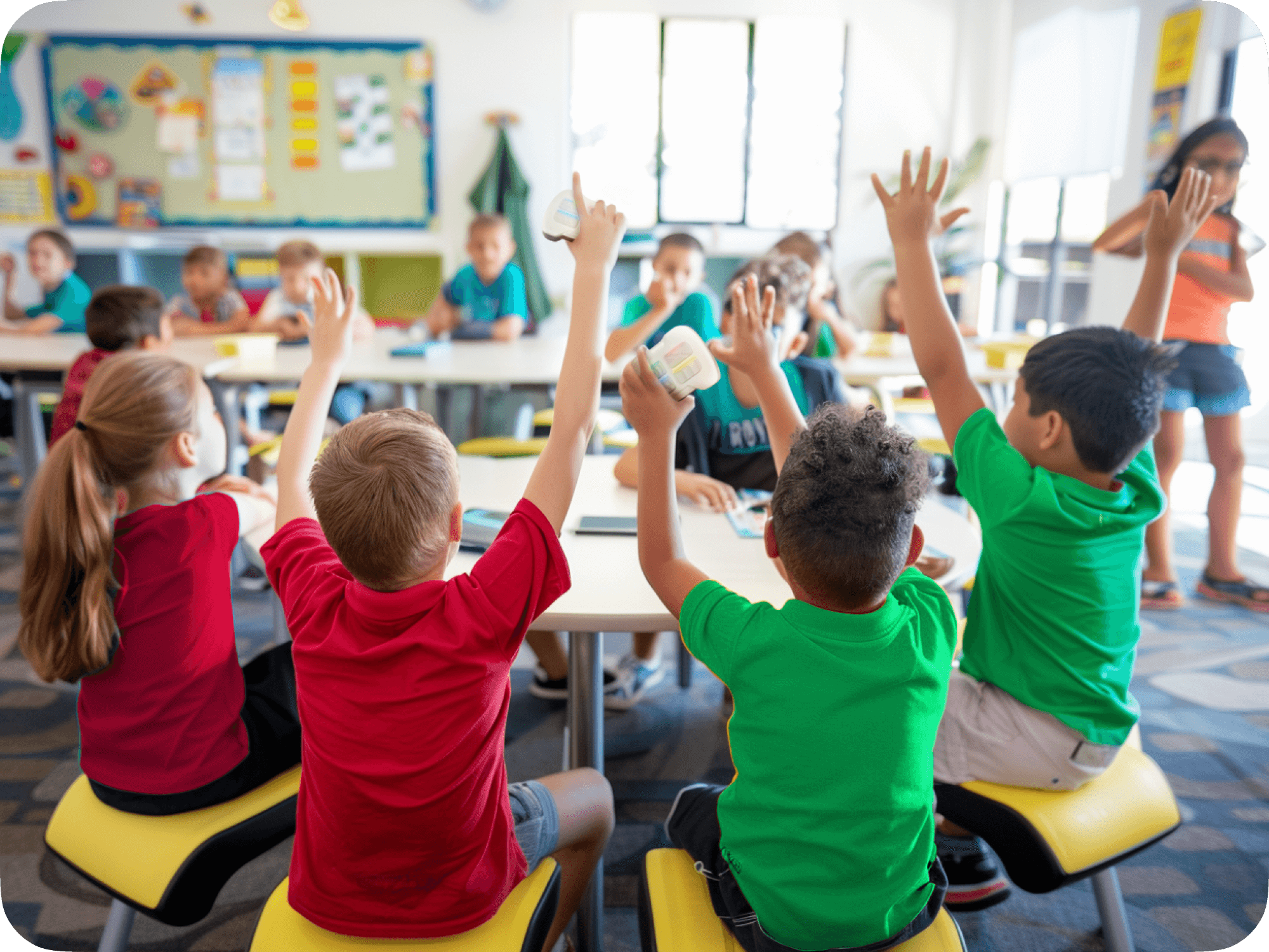 Students engaged in a classroom activity, raising hands enthusiastically during an interactive lesson.
