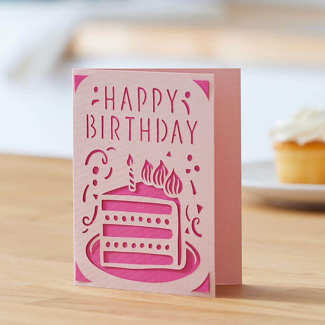 Pink 'Happy Birthday' card design featuring a layered cake with candles, ideal for personalized celebrations.