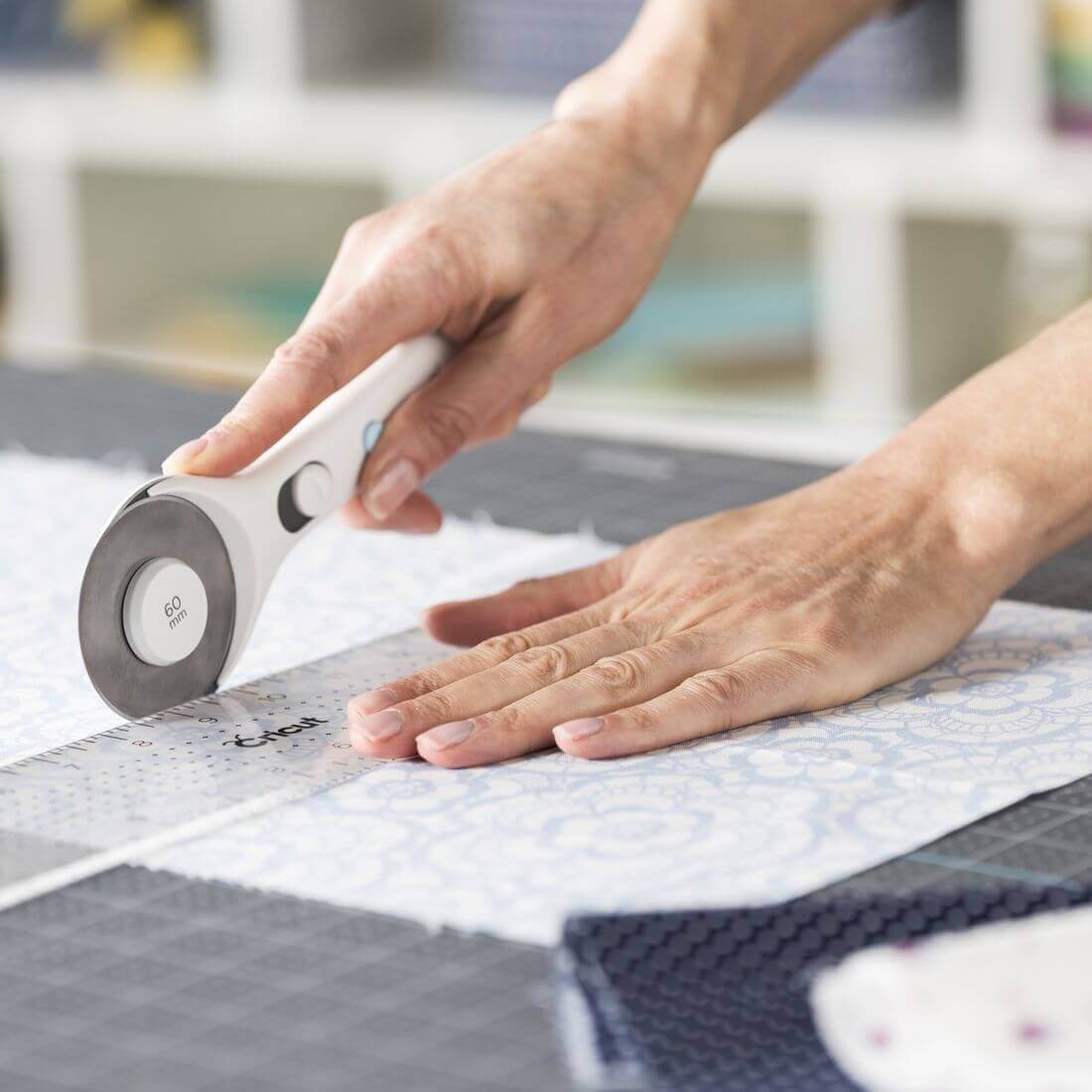 Cricut Rotary Cutter in use on fabric, highlighting 60mm blade for precise cutting of multiple layers and thicker materials.