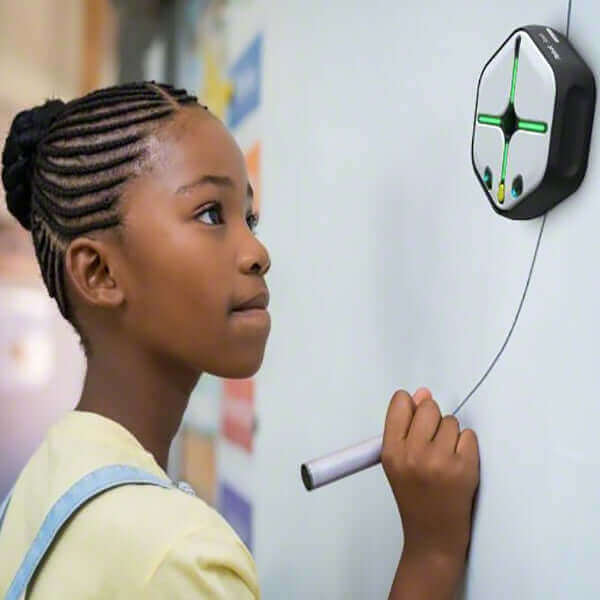 Young girl using IRobot Root Coding Robot to create art on a wall, showcasing creativity and coding skills.