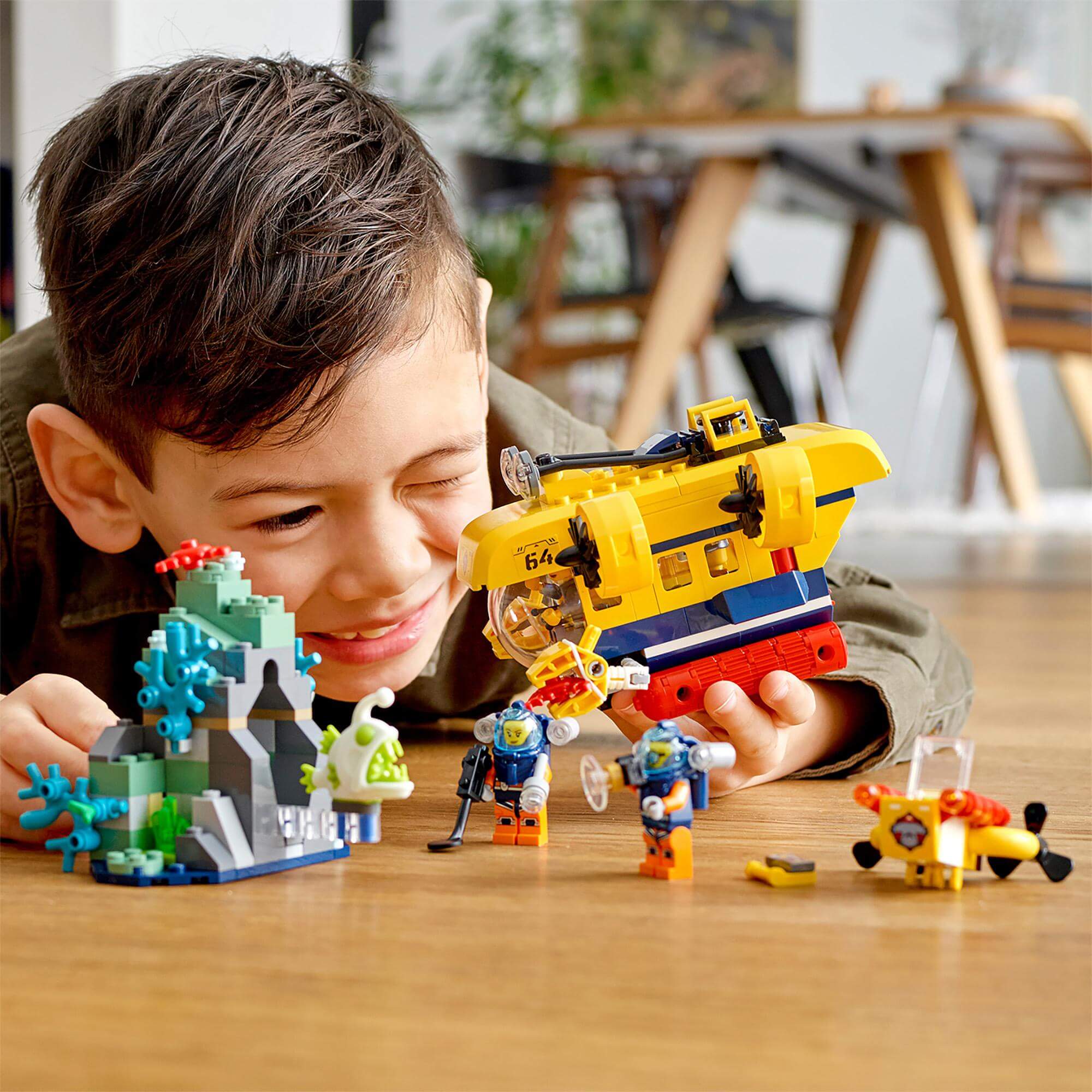 Child enjoying LEGO City Ocean Exploration Submarine set 60264 with colorful underwater scene and characters.