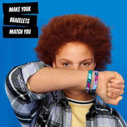 Child showing off LEGO® DOTS Starlight Bracelets, featuring teal and purple designs for personalized creativity.