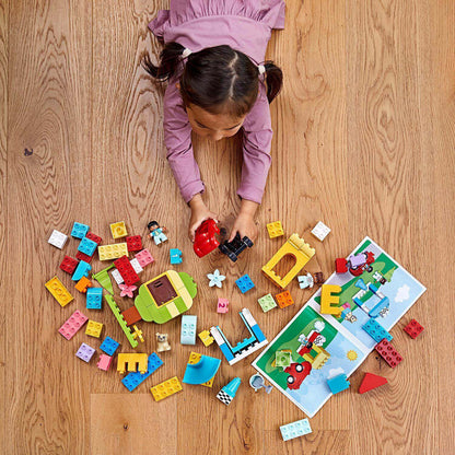 Toddler playing with LEGO® DUPLO Classic Deluxe Brick Box Set 10914, exploring colorful bricks and building fun.
