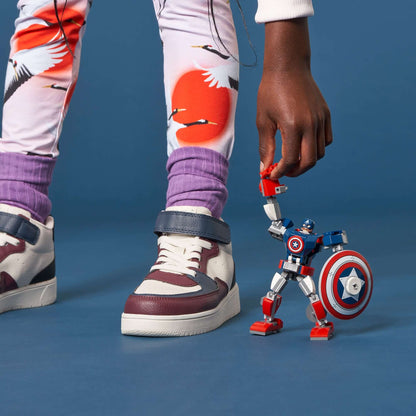 Child playing with LEGO® Marvel Avengers Captain America mech toy, featuring movable limbs and shield.