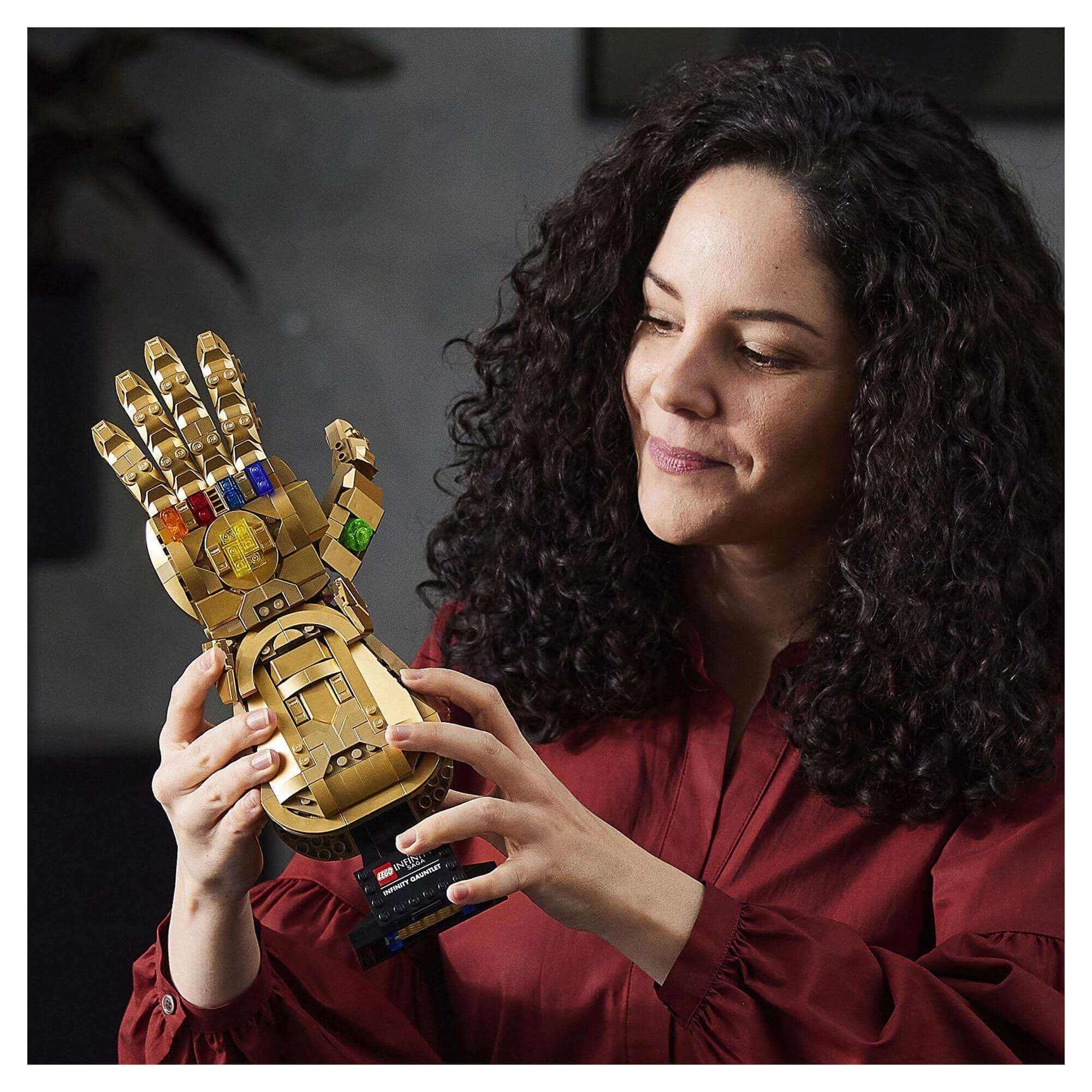Adult fan showcasing LEGO® Marvel Infinity Gauntlet Thanos Set 76191 with colorful Infinity Stones.