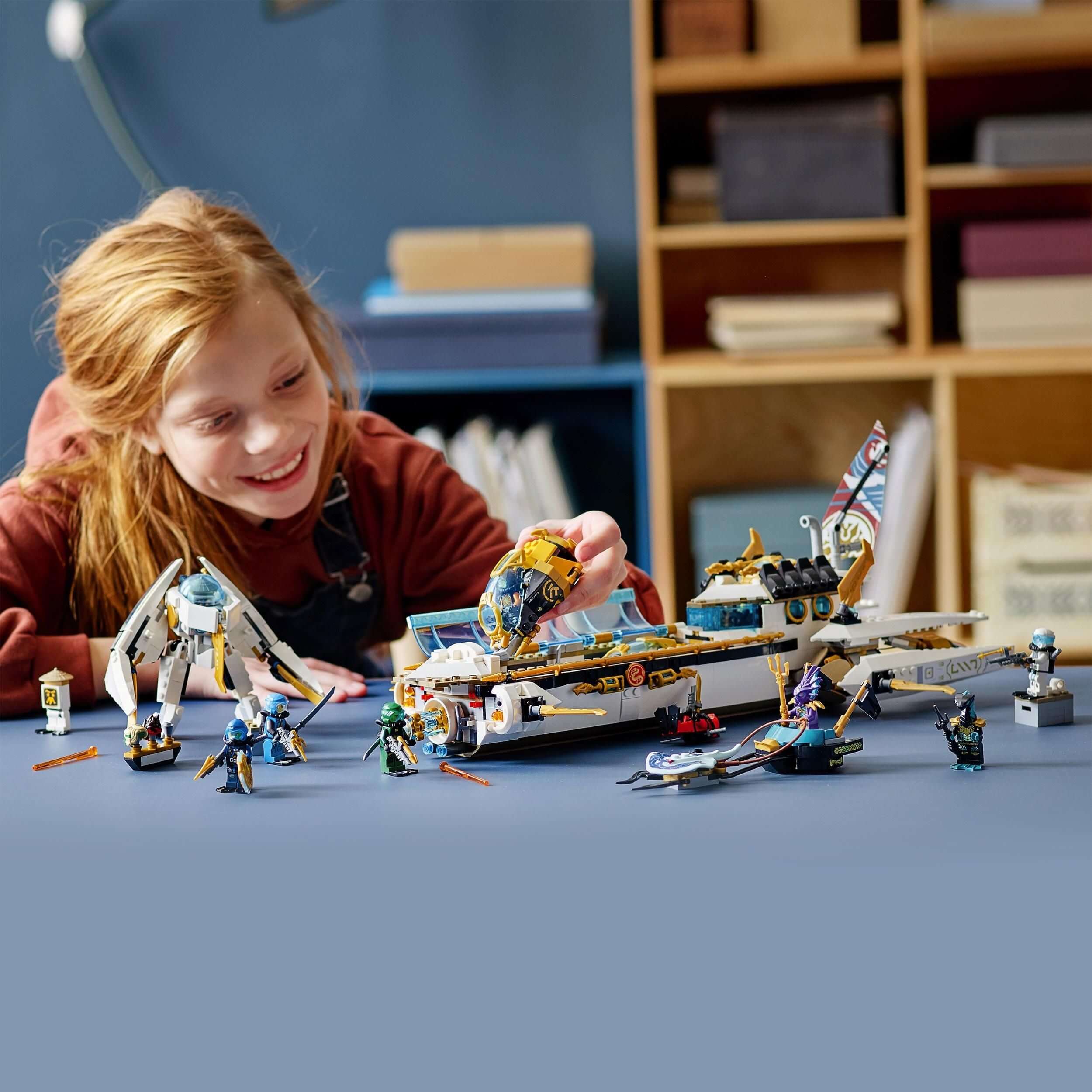 Child enjoying the LEGO® NINJAGO Hydro Bounty Submarine Set 71756 with multiple minifigures and play features.