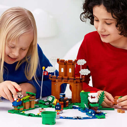 Children playing with LEGO® Super Mario™ Guarded Fortress set 71362, featuring action-packed adventure elements.