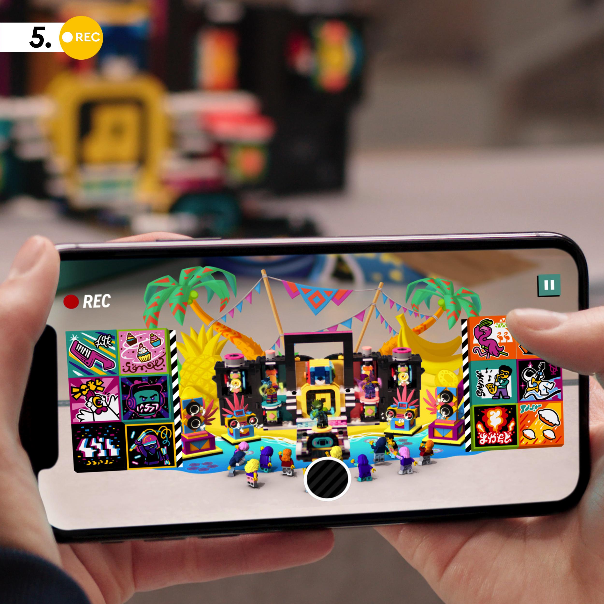 Child using LEGO VIDIYO app to create a music video with The Boombox BeatBox set 43115, featuring colorful backgrounds.