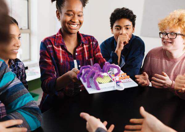Students engaged in a classroom demonstrating coding creativity with a littleBits invention.