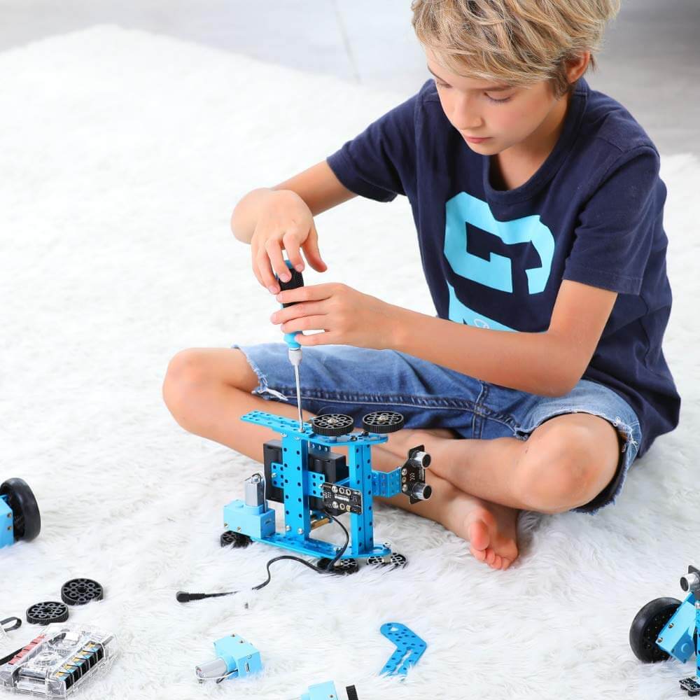 Child assembling Makeblock mBot Ranger robot kit, learning robotics and programming skills.