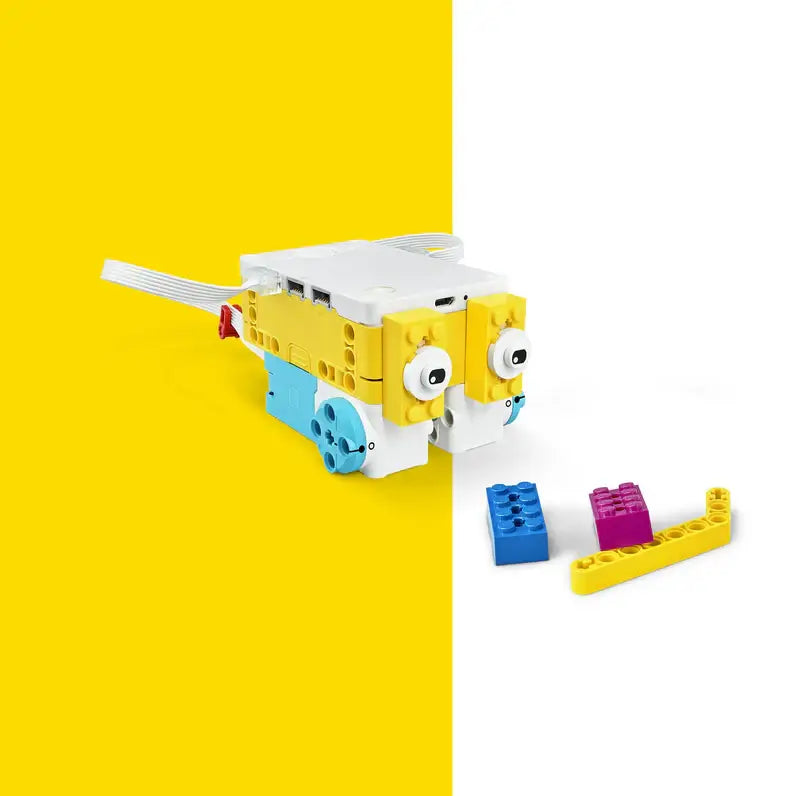 Colorful robotic toy with eyes and building blocks on a bright yellow background, inspiring creativity and learning.