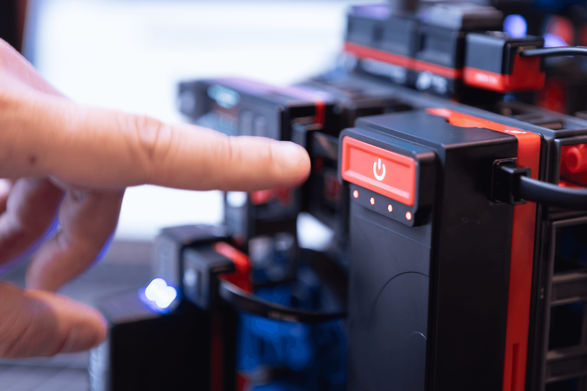 Close-up of a hand pressing the power button on a Sphero engineering kit for robotics education.
