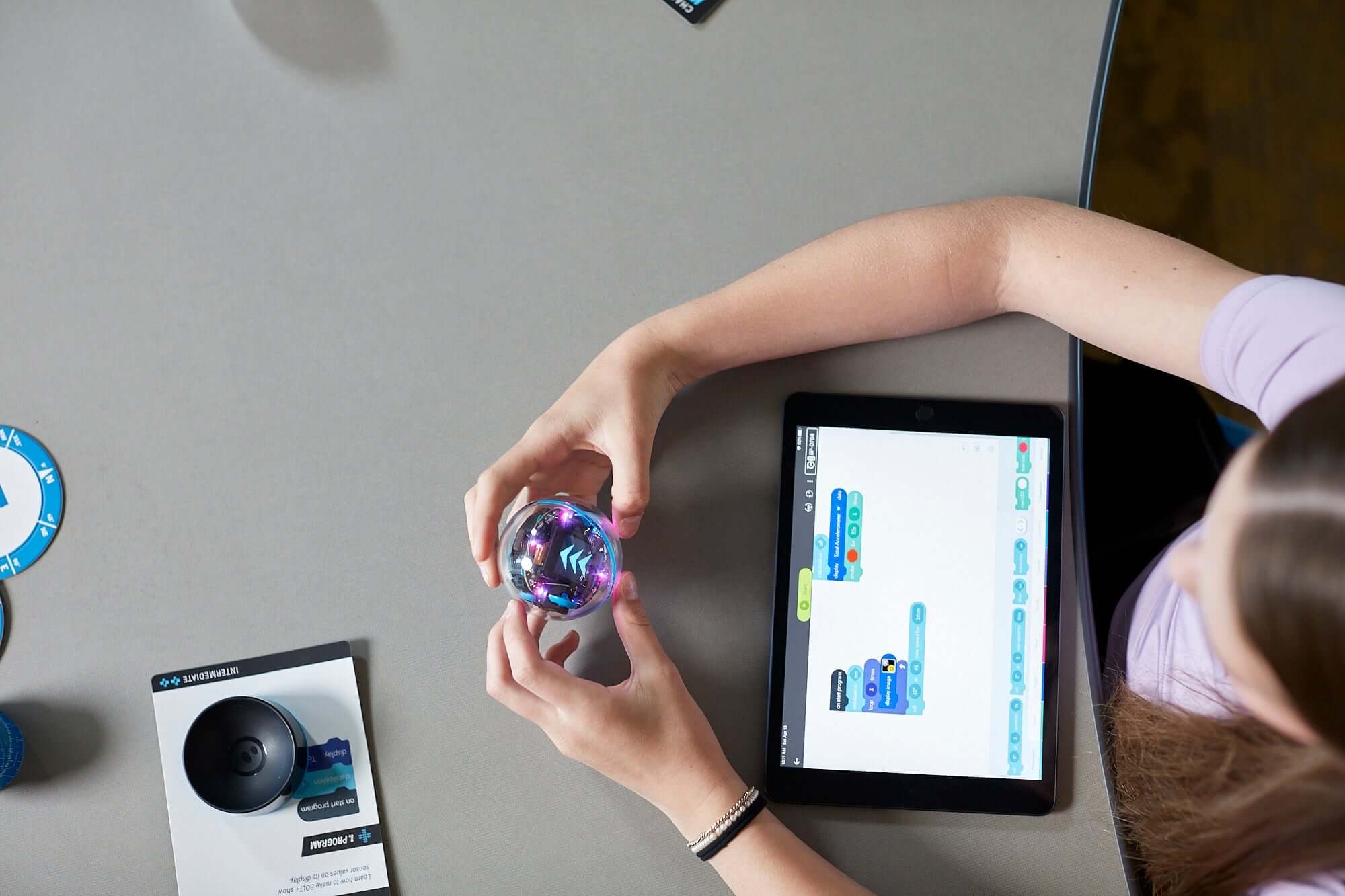 A student programming the Sphero BOLT+ robot using a tablet for hands-on coding education.