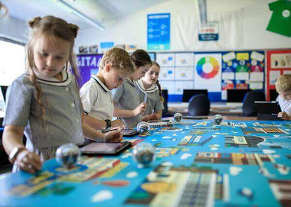 Students exploring coding activities on the Sphero Code Mat with tablets and robots in a classroom setting.
