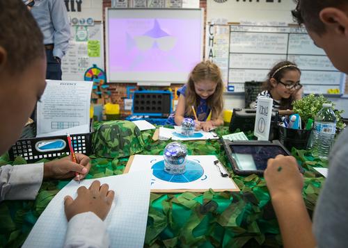 Students engaging with Sphero robots in a classroom, learning coding concepts in an interactive setting.