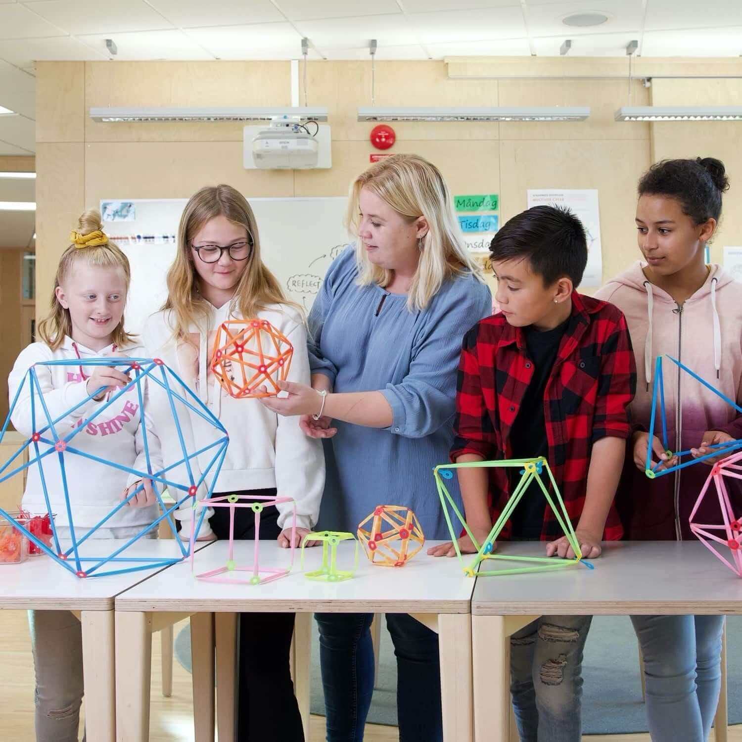 Students exploring 3D constructions with Strawbees in a classroom, enhancing STEAM skills and creativity.