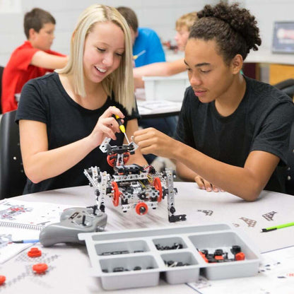 Two students assembling a TETRIX PRIME robot, showcasing teamwork and engineering creativity in robotics.