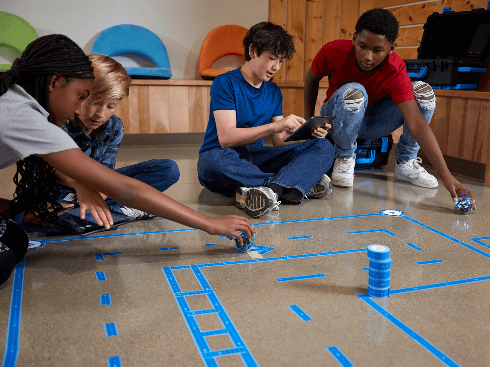 Kids engaged in coding with Sphero BOLT+, showcasing teamwork on a programmable robot project.
