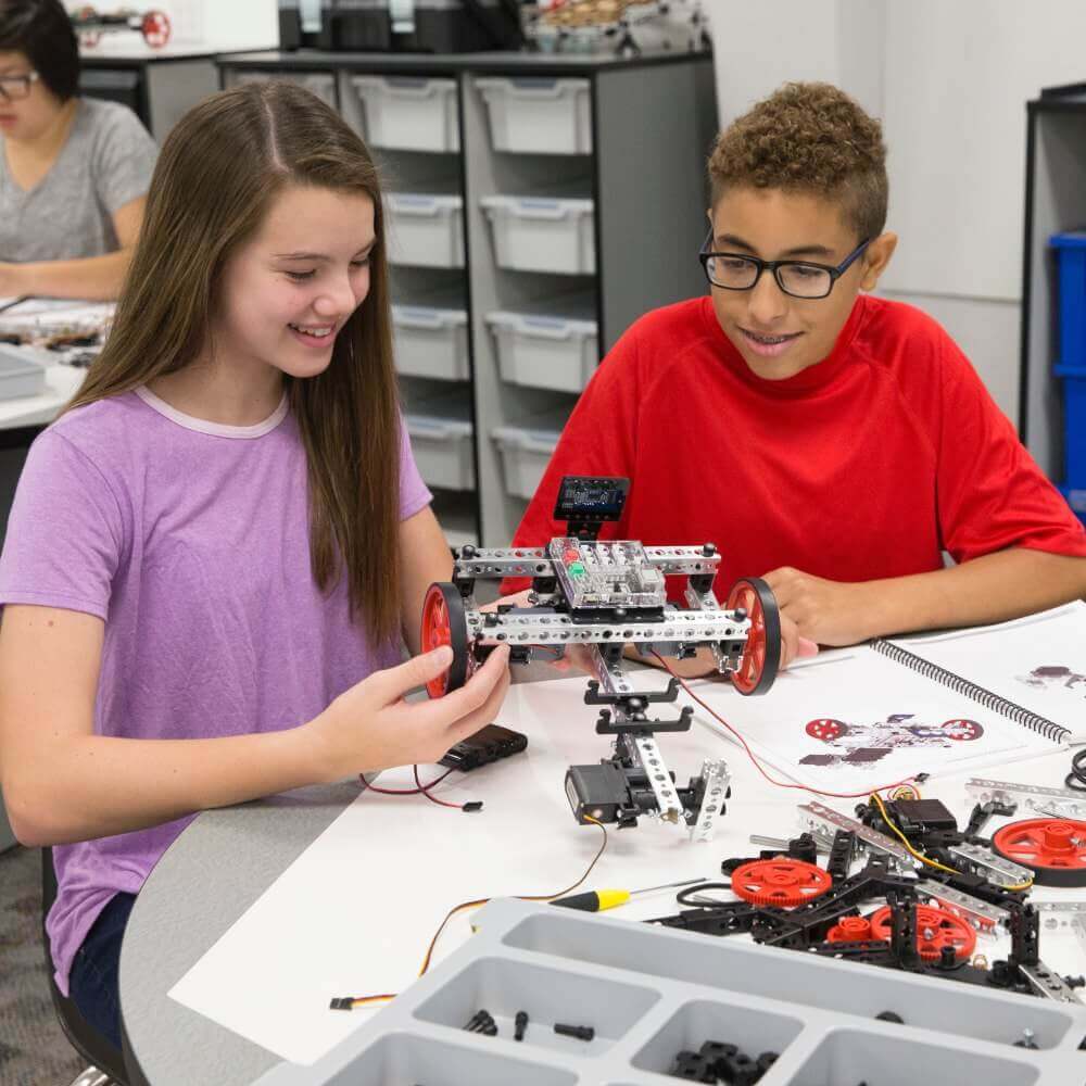 Students engaging with TETRIX PRIME robotics kit, building a remote-controlled robot in a classroom setting.